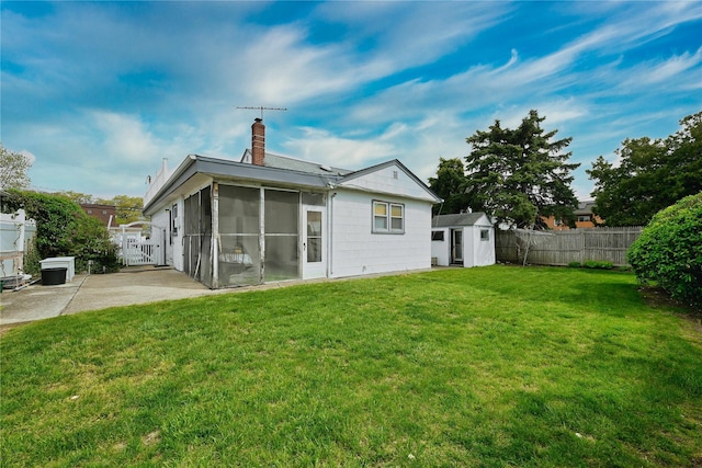 rear view of house featuring a sunroom, a storage unit, a fenced backyard, and a chimney