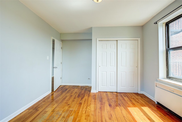 170-06 Crocheron Ave Unit 5D, Flushing, NY 11358 - unfurnished bedroom featuring light wood-style floors, baseboards, and a closet