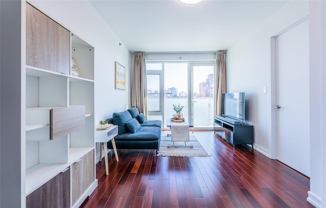 sitting room featuring baseboards and dark wood-style flooring