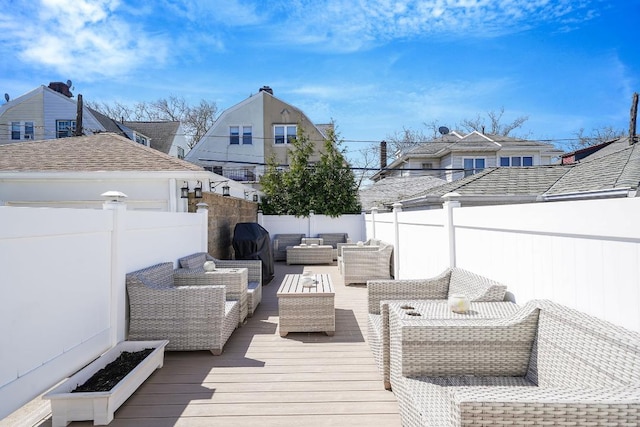 wooden terrace featuring a fenced backyard, an outdoor living space, and a residential view