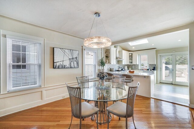 dining space with light wood-type flooring and lofted ceiling