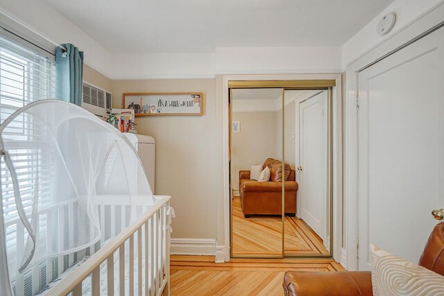 bedroom featuring wood finished floors, a closet, and baseboards