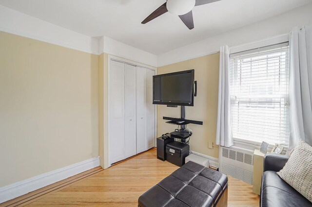 interior space featuring radiator, light wood finished floors, baseboards, and ceiling fan