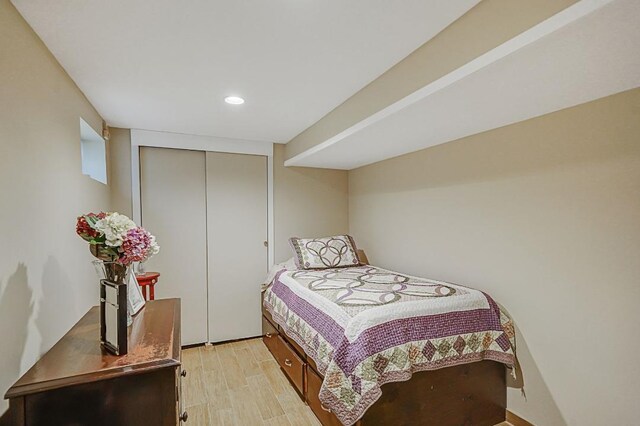 bedroom with recessed lighting, light wood finished floors, and a closet