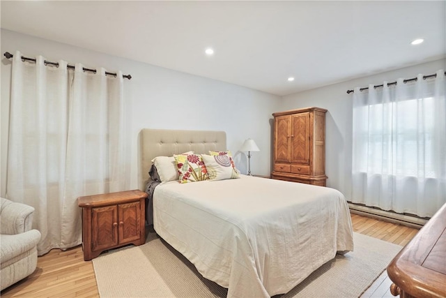 bedroom with a baseboard radiator, recessed lighting, and light wood-type flooring