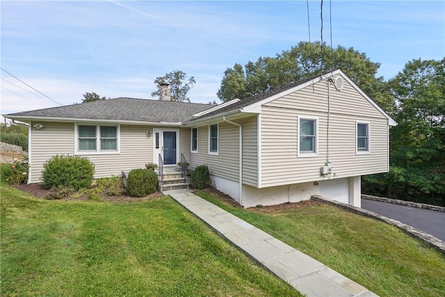 ranch-style house with a chimney, aphalt driveway, an attached garage, roof with shingles, and a front yard