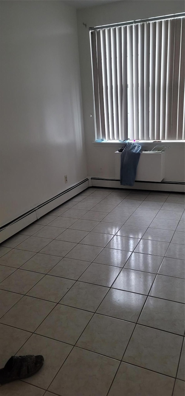 tiled spare room featuring a baseboard radiator
