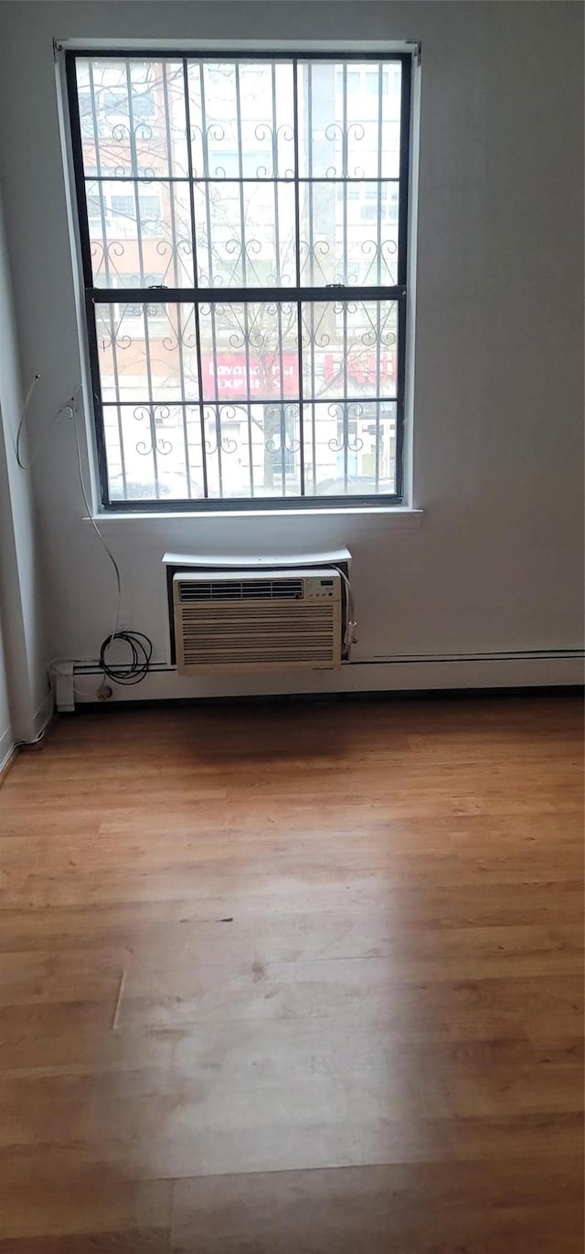 spare room with wood finished floors and a wall mounted air conditioner