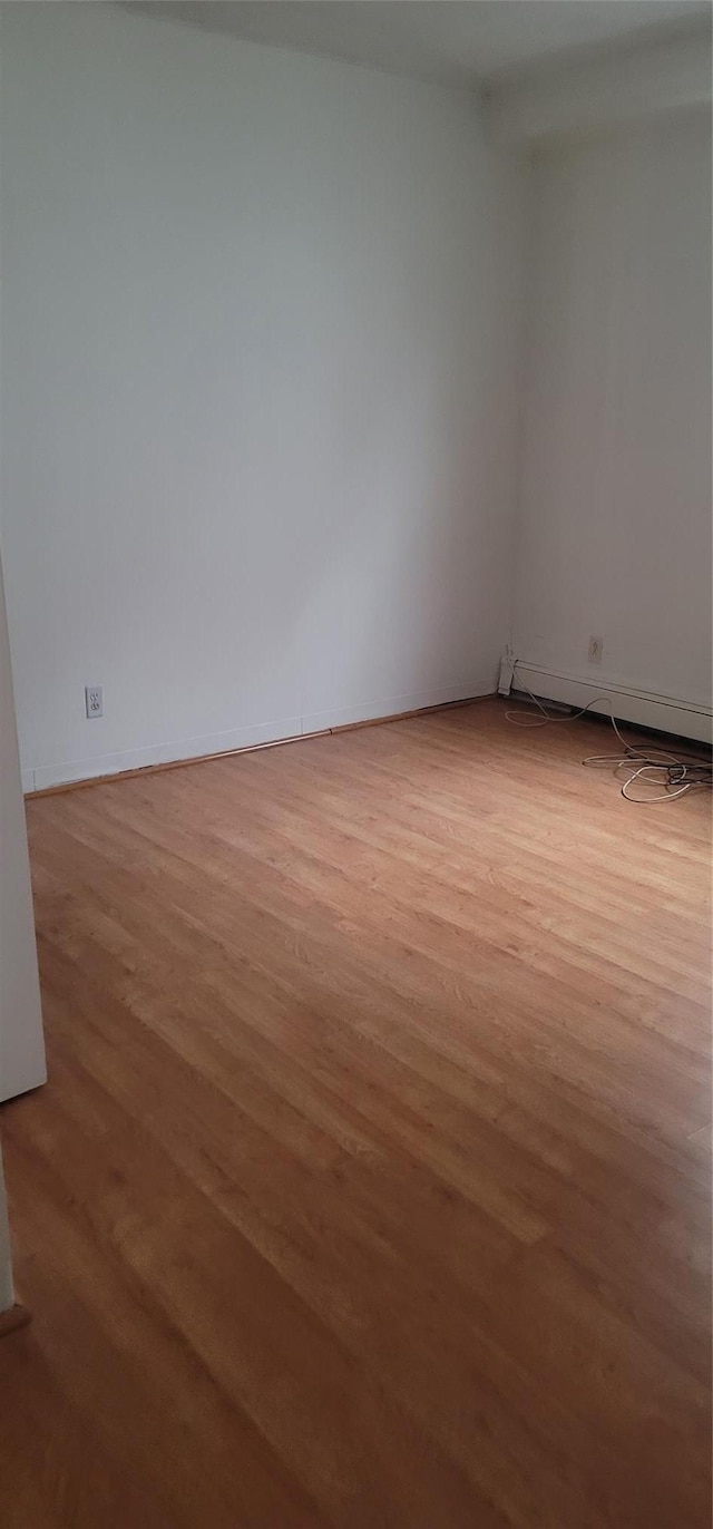 spare room with light wood-style flooring and baseboards