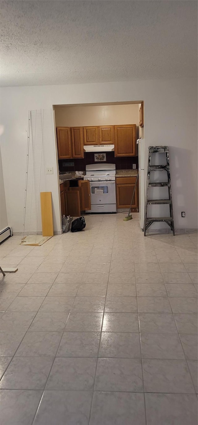 kitchen with white appliances, a textured ceiling, under cabinet range hood, brown cabinetry, and a baseboard radiator