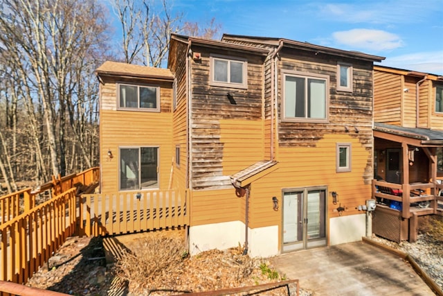 rear view of house with a wooden deck and french doors