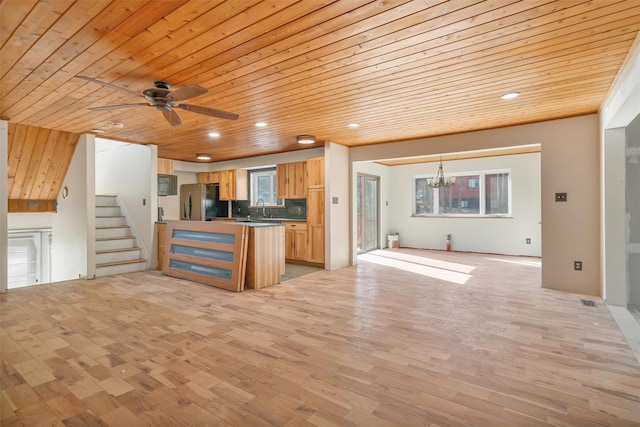 kitchen featuring wooden ceiling, a sink, stainless steel fridge, light wood-style flooring, and open floor plan