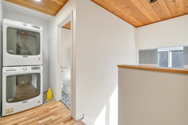 laundry area with stacked washer / drying machine, wood finished floors, laundry area, and wood ceiling