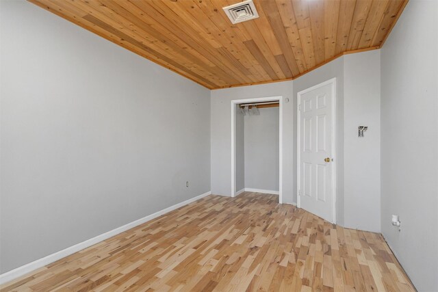 empty room with wood ceiling, baseboards, wood finished floors, and visible vents