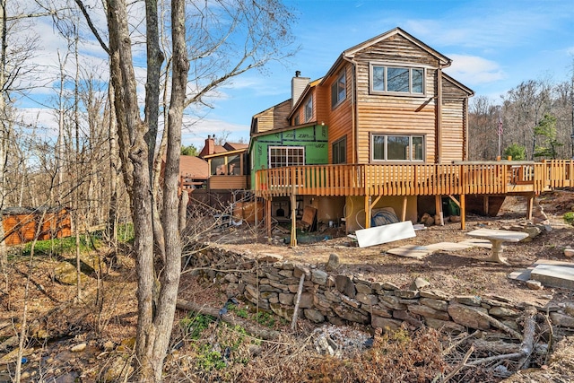 rear view of property with a chimney and a deck