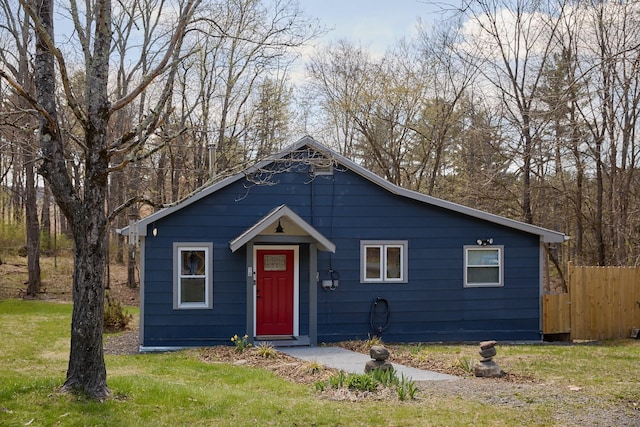 bungalow-style house featuring fence and a front lawn