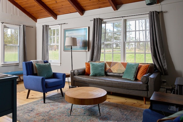 living room with lofted ceiling with beams, a wealth of natural light, light wood finished floors, and wood ceiling