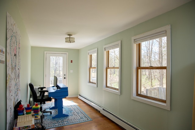 office area featuring a baseboard heating unit, wood finished floors, and plenty of natural light