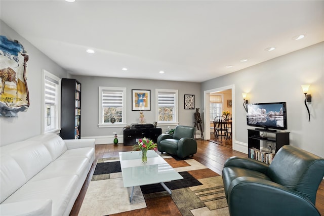 living area with baseboards, recessed lighting, and wood-type flooring