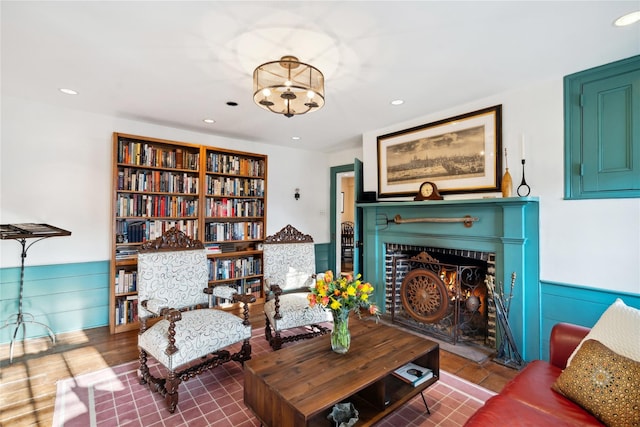 living area featuring a fireplace with flush hearth, a chandelier, and recessed lighting