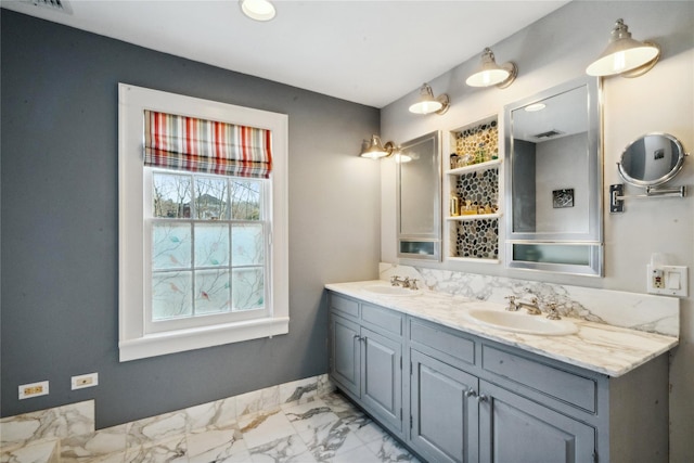 bathroom with double vanity, marble finish floor, and a sink