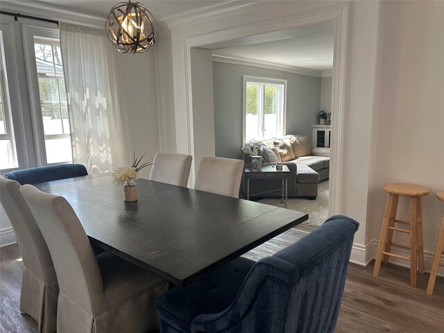 dining area featuring baseboards, dark wood-style floors, a chandelier, and ornamental molding