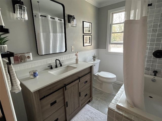 full bath featuring tiled shower / bath, wainscoting, vanity, toilet, and ornamental molding