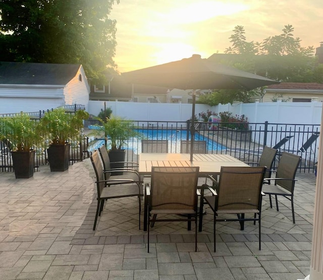view of patio with a fenced in pool, outdoor dining space, and a fenced backyard