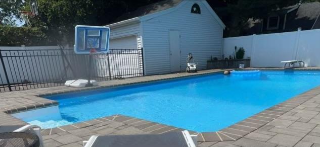 view of swimming pool featuring a fenced backyard, an outdoor structure, and a fenced in pool