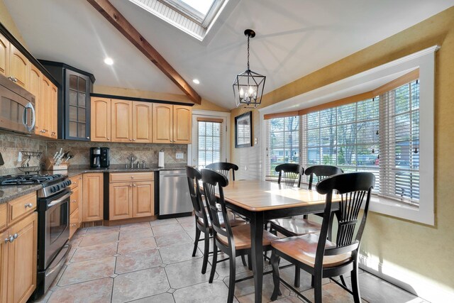 92 Dovecote Ln, Commack, NY 11725 - dining room featuring vaulted ceiling with skylight, an inviting chandelier, light tile patterned flooring, and a wealth of natural light