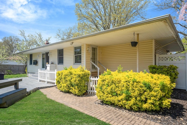 92 Dovecote Ln, Commack, NY 11725 - view of front facade featuring a front lawn, fence, a chimney, and a deck