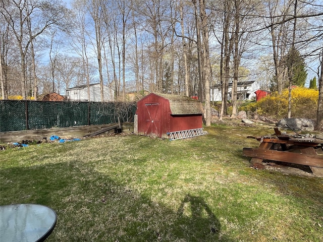 view of yard with fence, an outdoor structure, and a shed