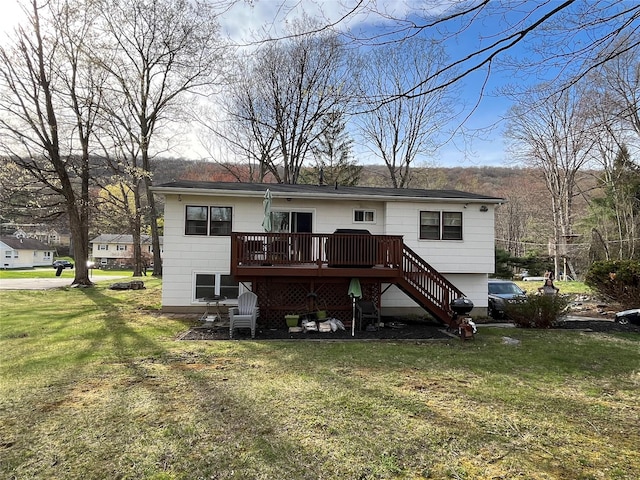 rear view of house featuring a lawn, a wooden deck, and stairs