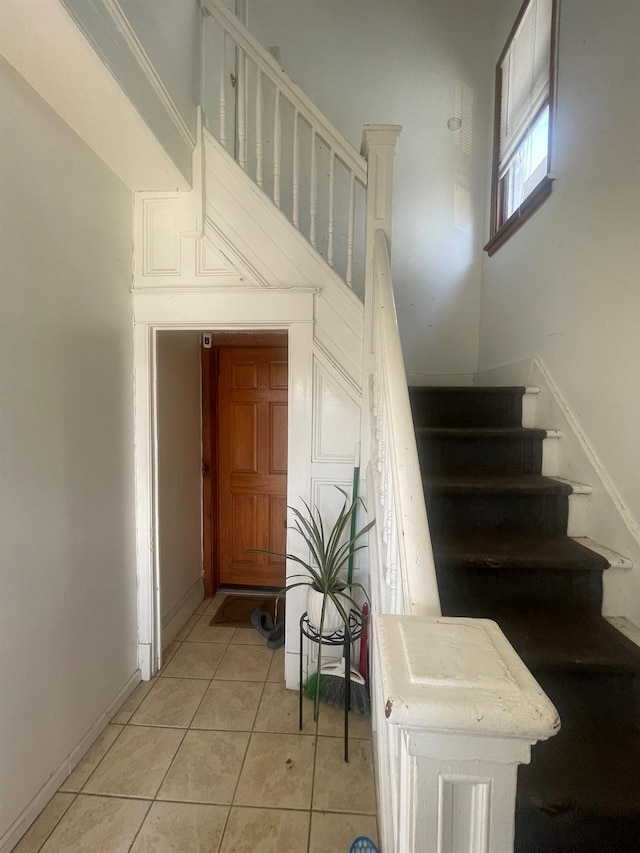 staircase with tile patterned flooring and baseboards