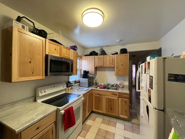 kitchen featuring light tile patterned floors, light countertops, a sink, and white appliances