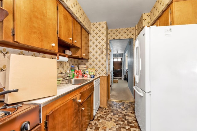 3530 Long Beach Rd Unit 68, Oceanside, NY 11572 - kitchen with brown cabinetry, white appliances, wallpapered walls, light countertops, and a sink