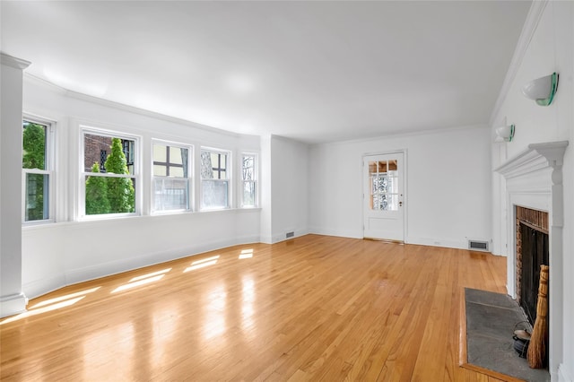 unfurnished living room with light wood finished floors, visible vents, and a wealth of natural light