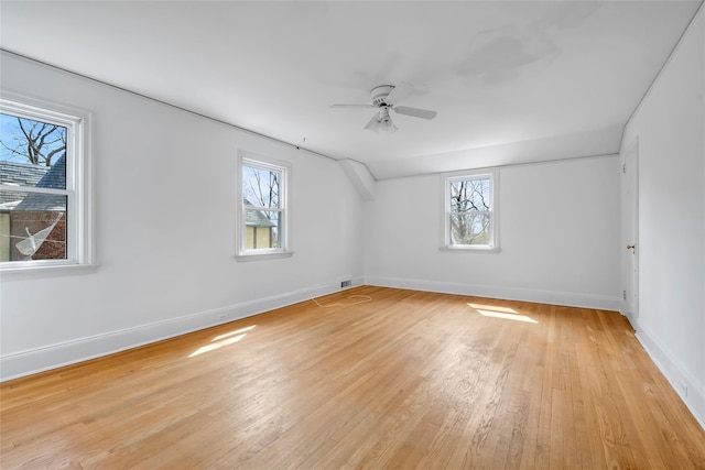 additional living space featuring visible vents, a ceiling fan, baseboards, and light wood-style floors