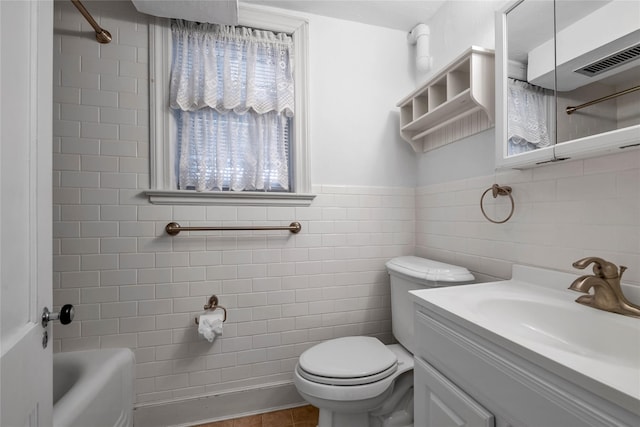 full bath with toilet, tile walls, shower / bathing tub combination, visible vents, and vanity