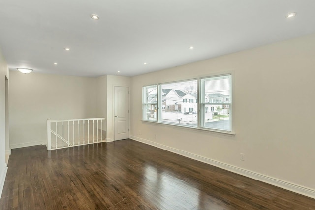 empty room featuring baseboards, wood finished floors, and recessed lighting