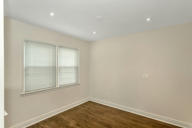 spare room with baseboards, dark wood-style flooring, and recessed lighting