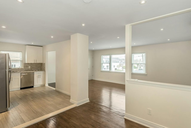 kitchen with wood finished floors, white cabinetry, a wealth of natural light, and stainless steel appliances