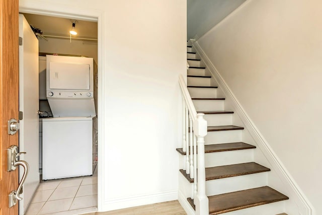 stairs with tile patterned flooring and stacked washer / drying machine