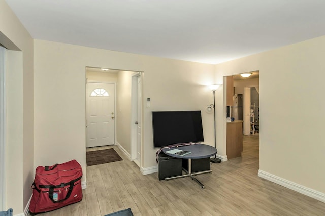 foyer entrance featuring light wood-style flooring and baseboards