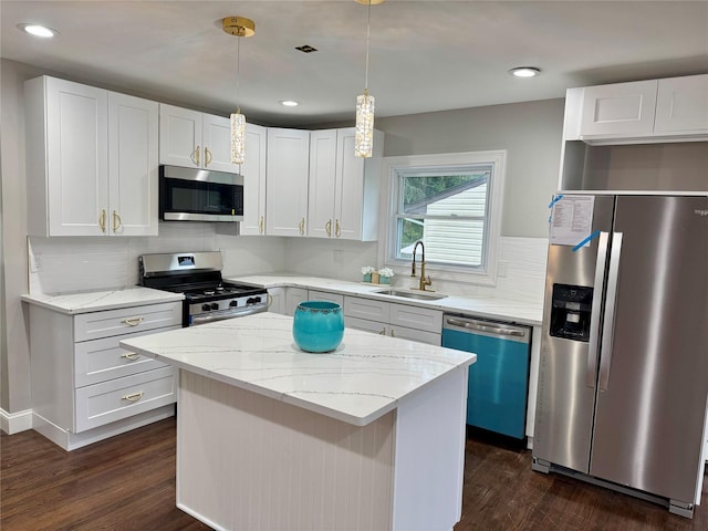 38 Moffitt Blvd, East Islip, NY 11730 - kitchen featuring stainless steel appliances, a sink, dark wood-style flooring, a kitchen island, and white cabinets
