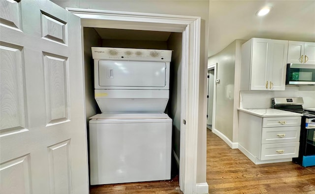 38 Moffitt Blvd, East Islip, NY 11730 - washroom featuring stacked washing machine and dryer and light wood finished floors