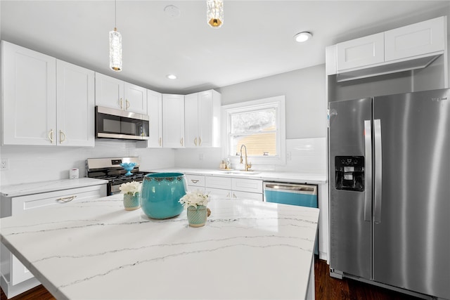 38 Moffitt Blvd, East Islip, NY 11730 - kitchen with stainless steel appliances, a sink, light stone counters, white cabinets, and recessed lighting