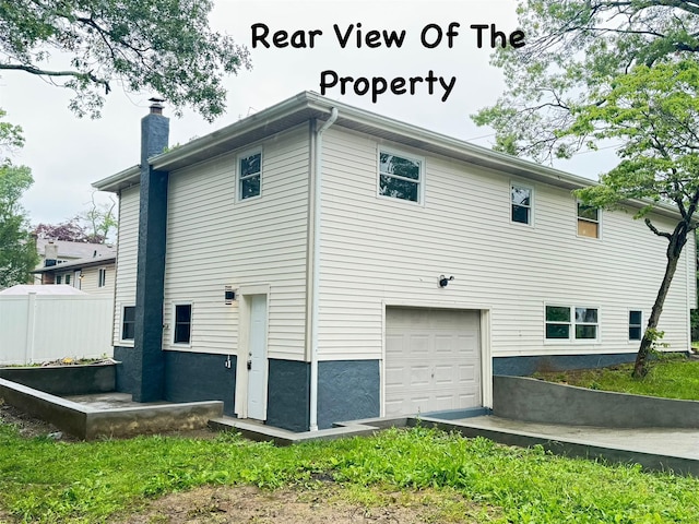 38 Moffitt Blvd, East Islip, NY 11730 - view of side of home with an attached garage and a chimney