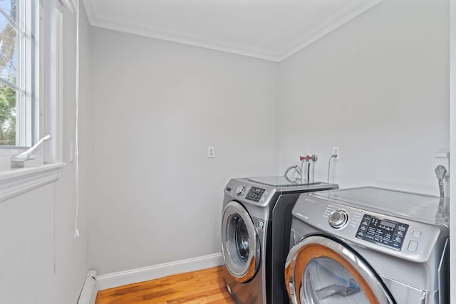 washroom with washing machine and clothes dryer, crown molding, wood finished floors, baseboards, and laundry area