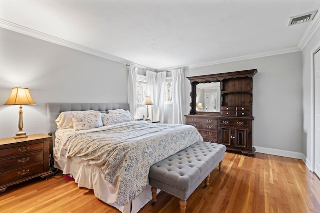 bedroom featuring baseboards, crown molding, visible vents, and light wood-style flooring